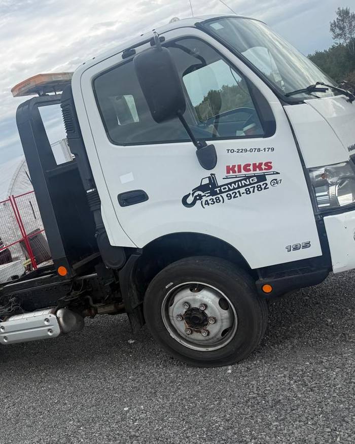 Cab door of the Kicks Towing truck showing the logo, phone number and Ontario certificate number
